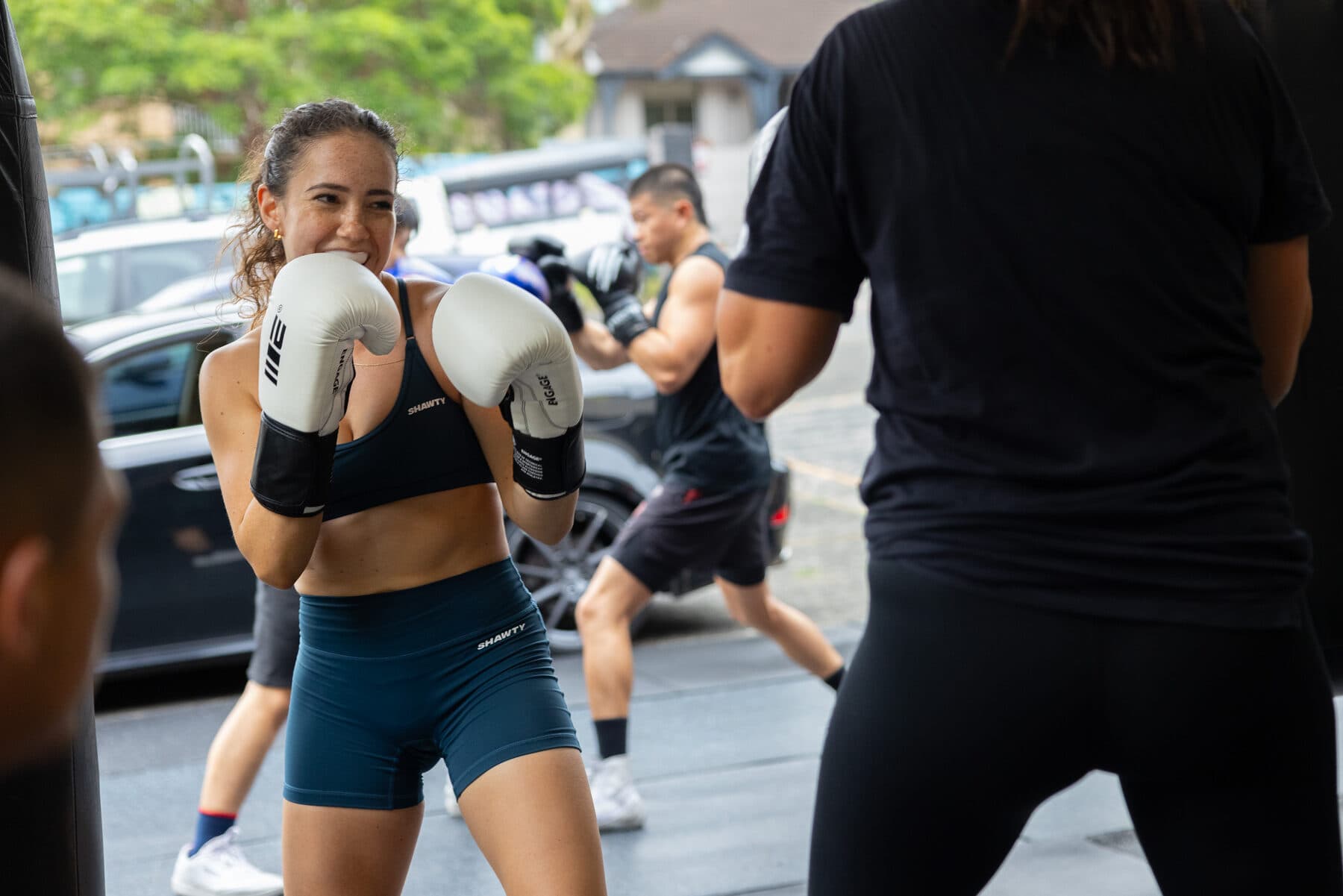 Coach guiding a beginner through pad work