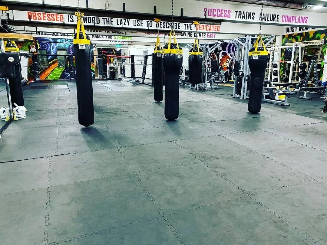 Indoor matted boxing floor and heavy bags at Legends Gym